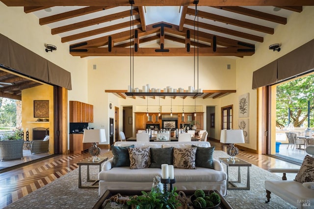 living room with plenty of natural light, beam ceiling, and high vaulted ceiling