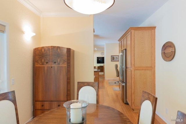 dining area with crown molding and light hardwood / wood-style flooring