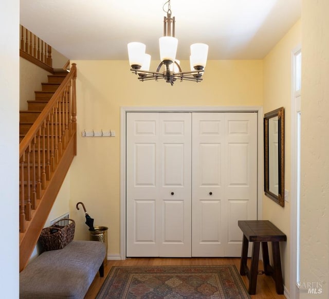 entryway with an inviting chandelier and wood-type flooring