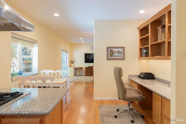 office area with light hardwood / wood-style floors and built in desk