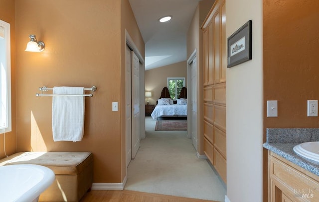 bathroom with vanity and lofted ceiling