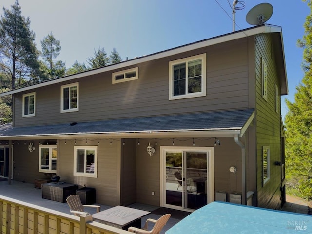 back of property with a patio area and an outdoor living space