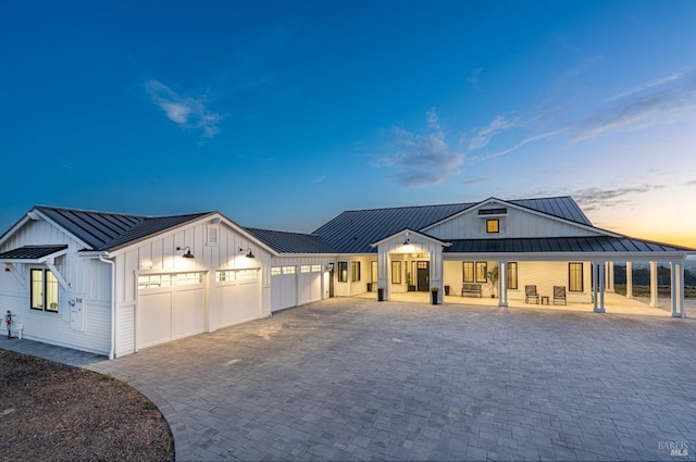 modern farmhouse featuring covered porch and a garage