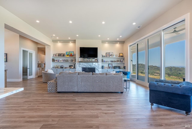 living room with ceiling fan and light wood-type flooring