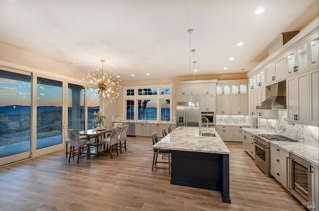 kitchen with pendant lighting, high quality appliances, hardwood / wood-style flooring, decorative backsplash, and a large island