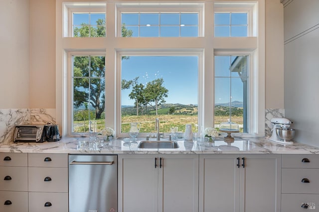 kitchen with light stone countertops, plenty of natural light, and white cabinets