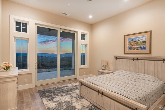 bedroom featuring access to exterior and light hardwood / wood-style flooring