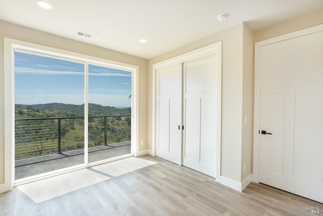 unfurnished bedroom featuring a closet and light hardwood / wood-style flooring