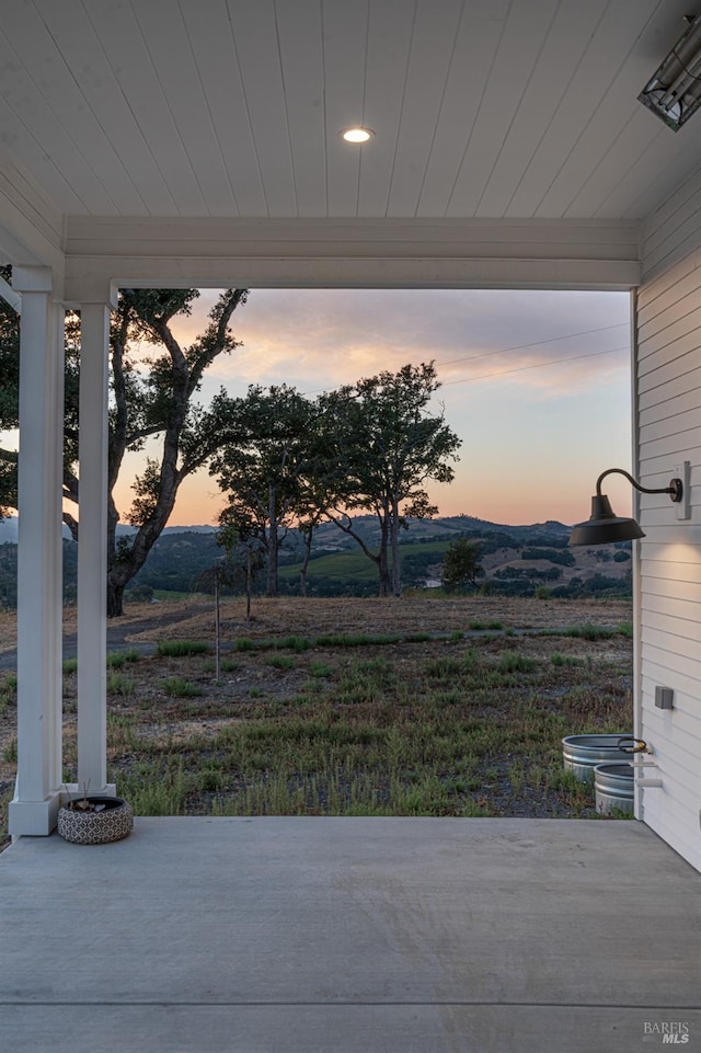 patio terrace at dusk featuring a rural view