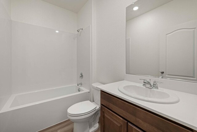 full bathroom with hardwood / wood-style floors, vanity, toilet, and shower / washtub combination