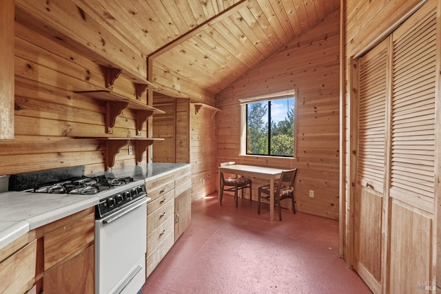 kitchen with white range with gas stovetop, wooden ceiling, lofted ceiling, and wooden walls