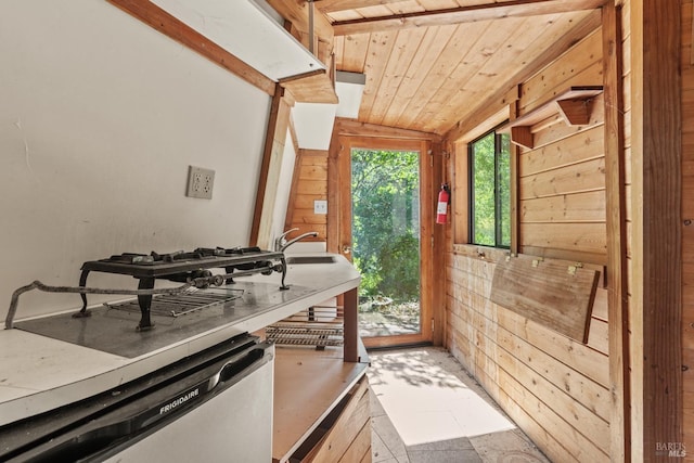 interior space featuring wood walls, wooden ceiling, tile flooring, sink, and lofted ceiling