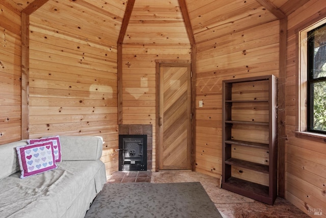 interior space with a wood stove, wood walls, wooden ceiling, and lofted ceiling