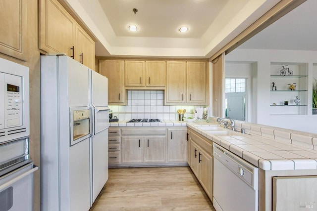 kitchen featuring light hardwood / wood-style floors, tile counters, light brown cabinetry, sink, and appliances with stainless steel finishes