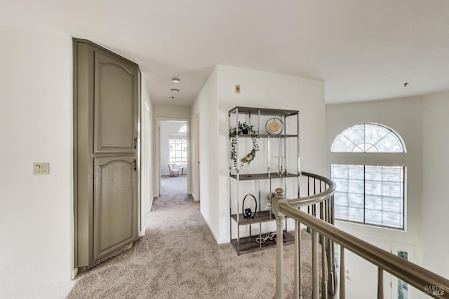 hall featuring plenty of natural light and light colored carpet