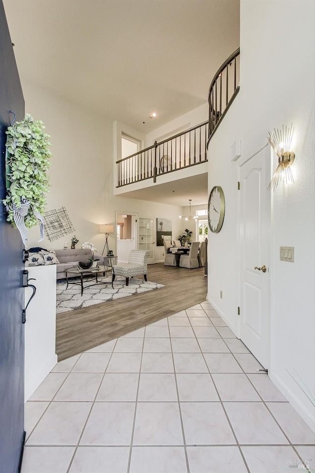 tiled entryway with a towering ceiling