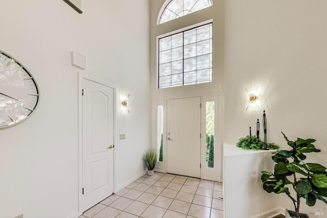 foyer entrance featuring a towering ceiling and light tile flooring