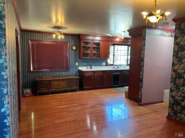 kitchen featuring a chandelier, ornamental molding, a textured ceiling, and light hardwood / wood-style flooring