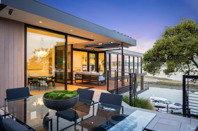 patio terrace at dusk with a water view and outdoor lounge area