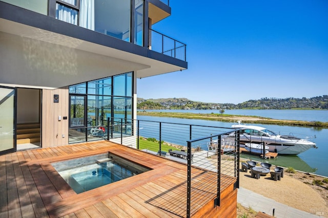 exterior space with a balcony, a water view, and a fire pit