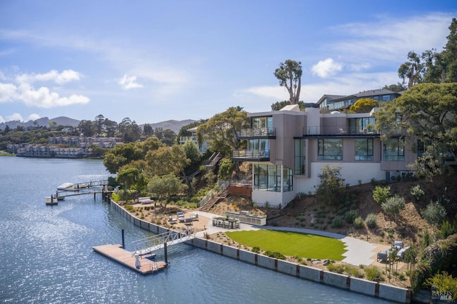 exterior space with a water and mountain view and a boat dock