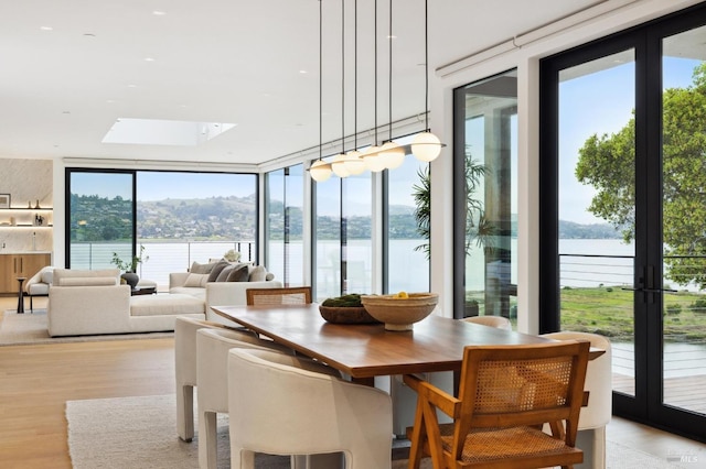 sunroom / solarium featuring a water view and plenty of natural light