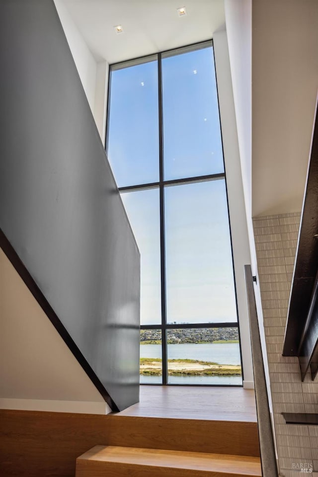 431 E Strawberry Dr, Mill Valley, CA 94941 - staircase with floor to ceiling windows, a water view, and wood finished floors