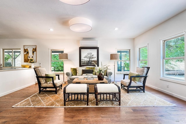 dining space featuring a wealth of natural light, wood finished floors, and a wall unit AC