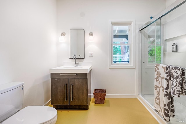 full bath featuring baseboards, a shower stall, vanity, and toilet