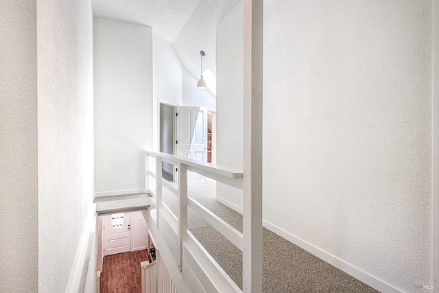 corridor with carpet flooring and lofted ceiling