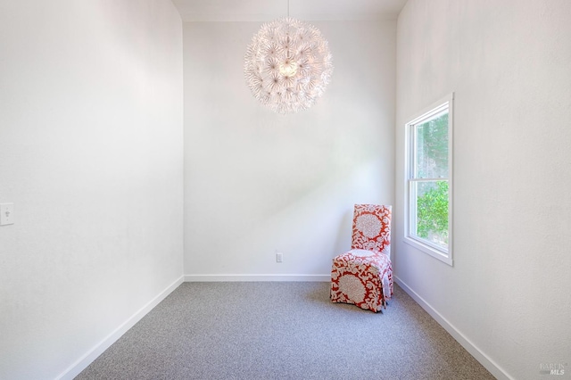 unfurnished room with a notable chandelier, baseboards, and carpet