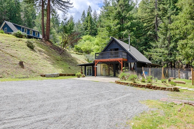 view of front of property featuring board and batten siding and gravel driveway