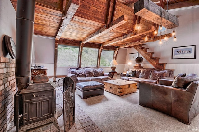 living room with beamed ceiling, a wood stove, and wooden ceiling