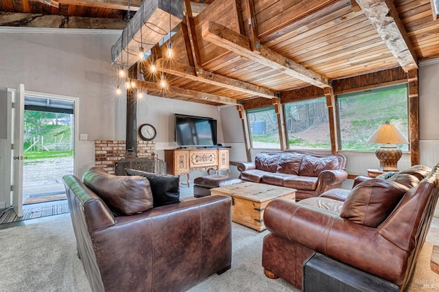 carpeted living room with beam ceiling, wooden ceiling, plenty of natural light, and a wood stove