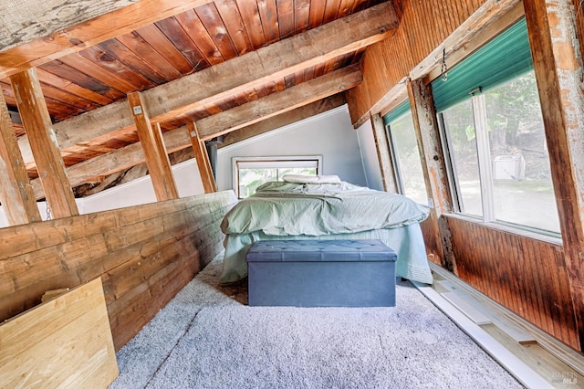 unfurnished bedroom featuring lofted ceiling with beams, wooden walls, multiple windows, and wood ceiling