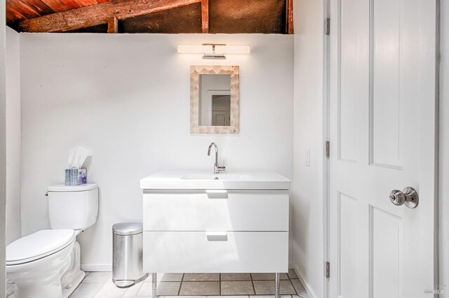 bathroom featuring tile flooring, vanity, and toilet