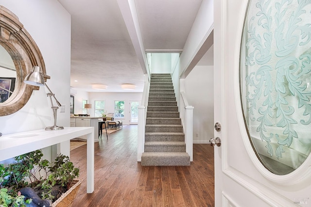 foyer with stairs, baseboards, and dark wood-style flooring