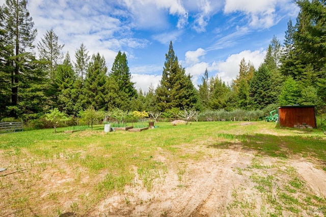 view of yard featuring an outdoor structure and fence