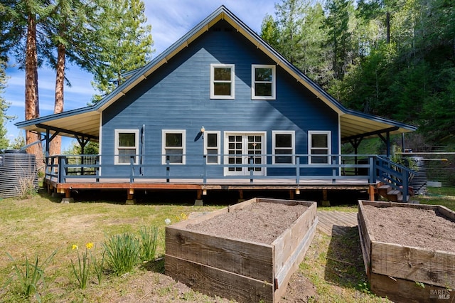 back of property with a lawn and a wooden deck