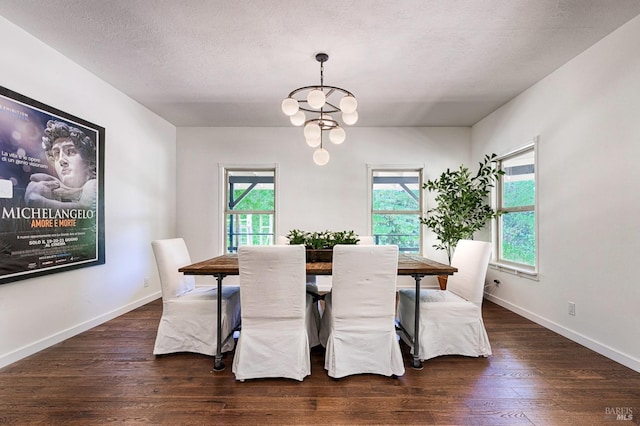 dining room featuring a notable chandelier, a textured ceiling, and dark wood-type flooring