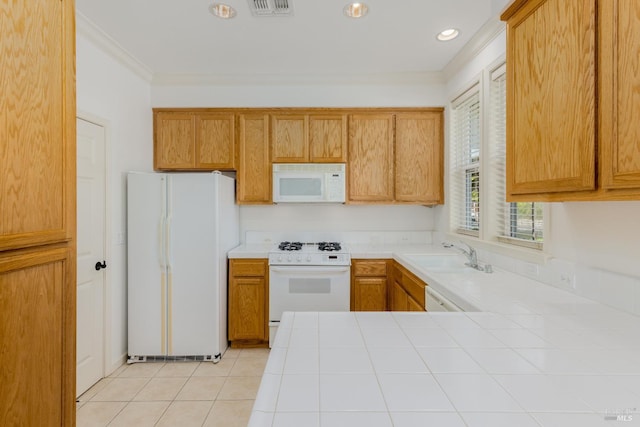 kitchen with tile countertops, light tile patterned flooring, white appliances, a sink, and crown molding