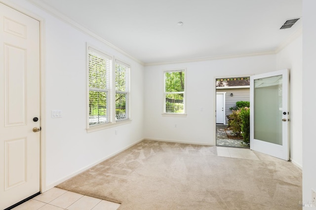 empty room featuring light carpet, crown molding, visible vents, and baseboards