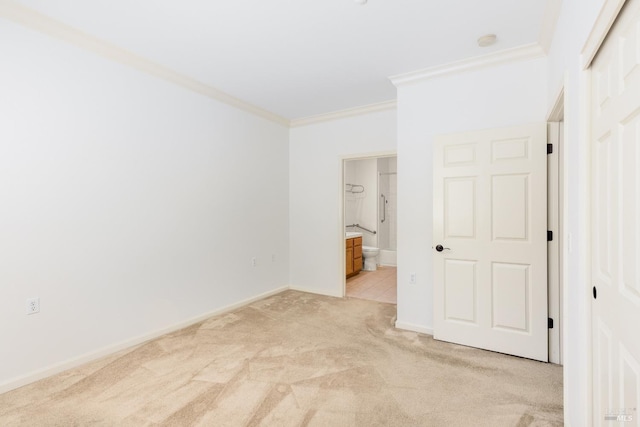 empty room featuring ornamental molding, light colored carpet, and baseboards