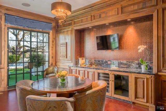 dining space featuring dark parquet floors, ornamental molding, an inviting chandelier, and wine cooler