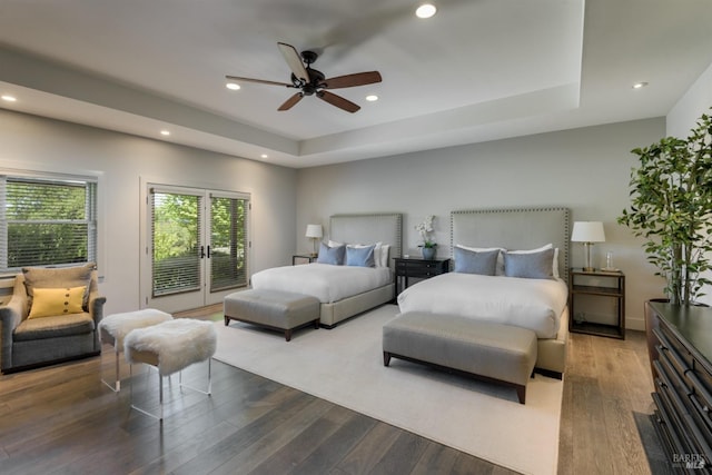 bedroom featuring ceiling fan, a tray ceiling, hardwood / wood-style flooring, and access to outside