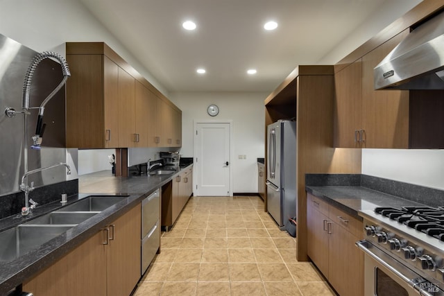 kitchen with stainless steel appliances, sink, wall chimney exhaust hood, and light tile flooring