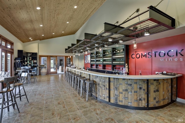 bar featuring tile floors, a high ceiling, french doors, and wooden ceiling