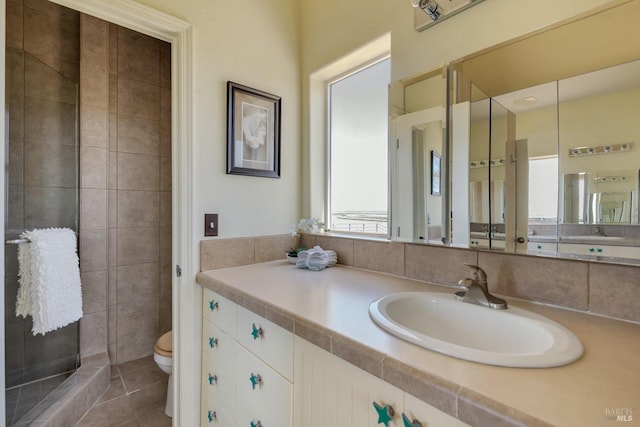 bathroom with walk in shower, tile patterned flooring, vanity, and toilet