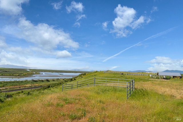 view of yard with a rural view and a water and mountain view