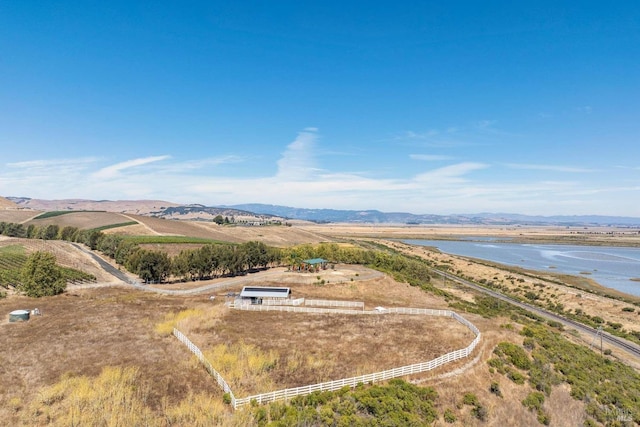 drone / aerial view with a water and mountain view and a rural view